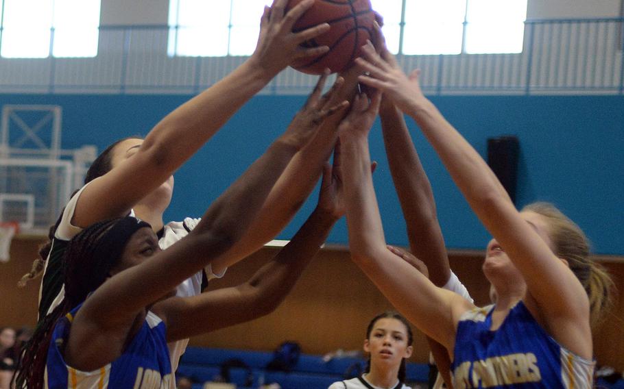 Daegu's Jasmine Harvey and Yokota's Beverly Gardner and Charlotte Rhyne reach for a rebound during Monday's Far East Girls Division II pool-play game, won by the Panthers 35-27.