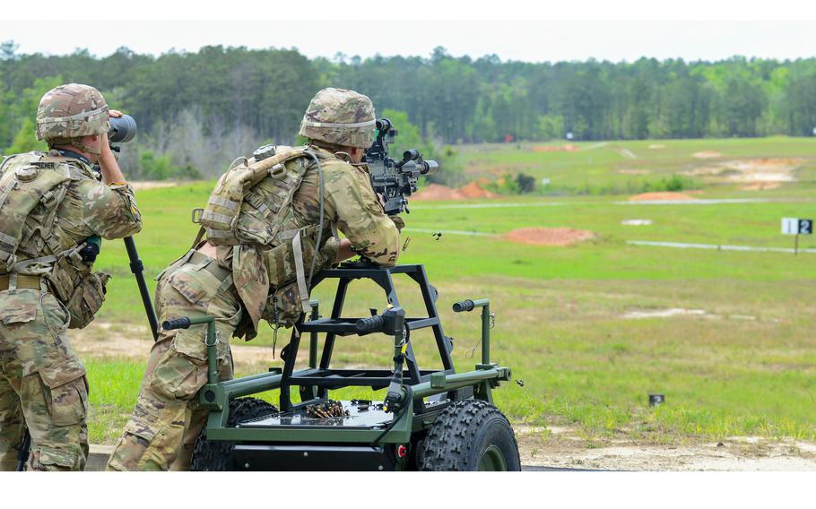 Army 2nd Lt. Nathaniel Lacorte fires a machine gun as 1st Lt. Copeland Zaunbrecher looks on during a live-fire event at Fort Benning, Ga., during the Best Ranger Competition, Friday, April 14, 2023. The two lieutenants represented the Army National Guard in the grueling three-day competition.  