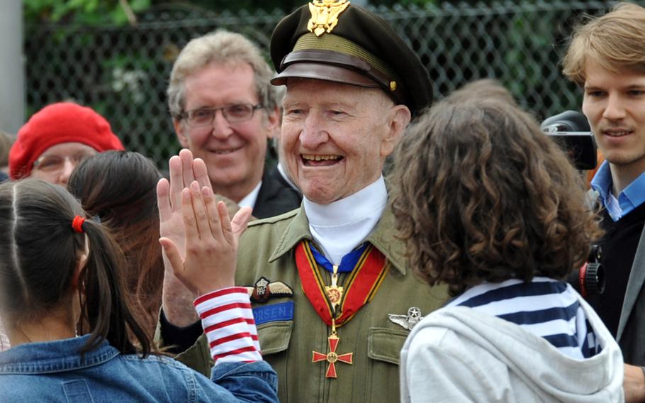 Retired Col. Gail Halvorsen, the “Candy Bomber,” high-fives a member of a school choir after their performance at the commemoration ceremony of the 65th anniversary of the Berlin Airlift at Frankfurt Airport, Wednesday, June 26, 2013.