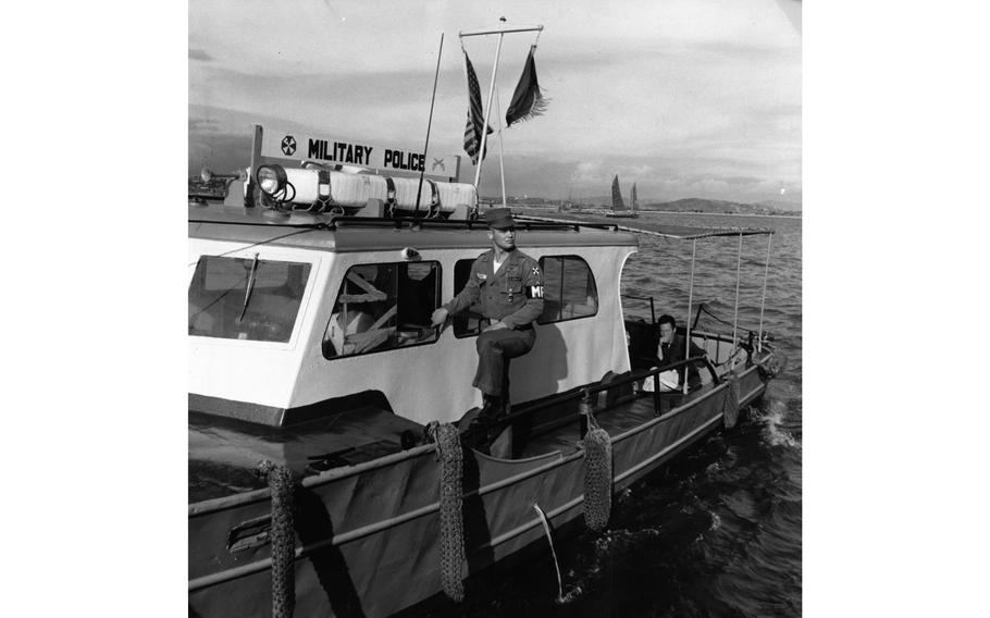 PFC Jackie P. Justice of the 8224th Military Police Detachment scrutinizes the traffic as the patrol boat weaves slowly through Incheon harbor. Part of the detachment stationed in Inchon have traded their Jeep in for a J boat to form the Inchon Harbor Patrol. Everything that floats, from freighters to sampans, comes under the patrol’s watchful eye.