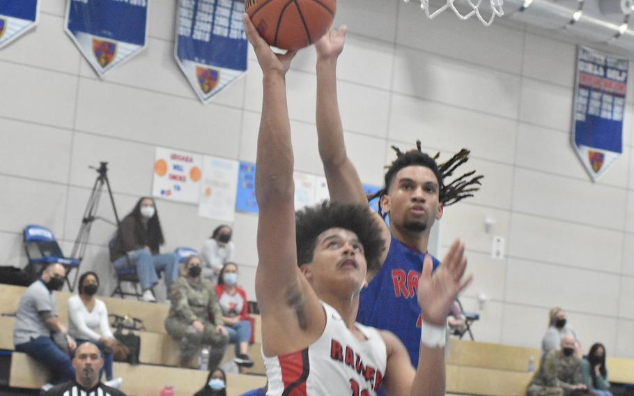 Kaiserslautern’s Keenan Garner gets past Ramstein’s Ezra Woodfork to score a basket in the Raiders’ 56-43 victory Wednesday, Feb. 23, 2022, at the DODEA-Europe Division I basketball tournament.