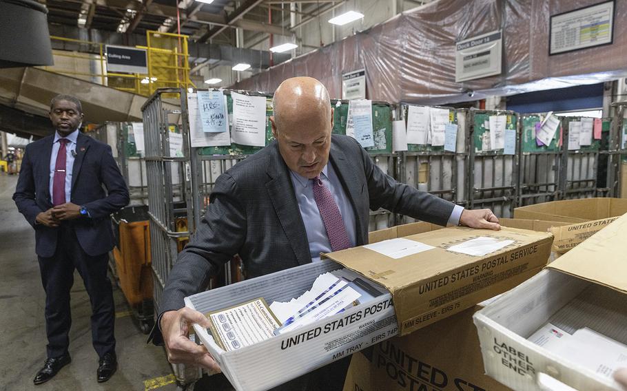 U.S. Postmaster General Louis DeJoy checks a carrier tray at a facility near Atlanta. 