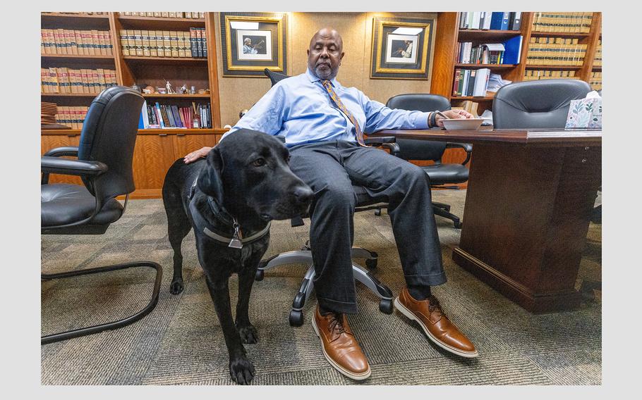 Chief Judge Ural Glanville sits in his Fulton County courtroom office with his service dog, Jack, on Sept. 26, 2023.