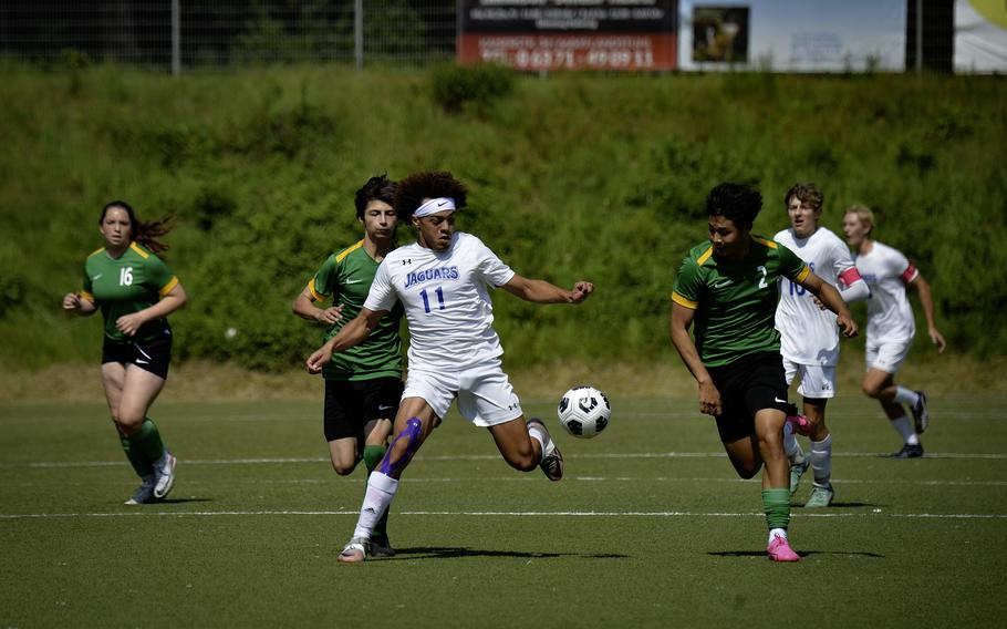Jayden Reed of Sigonella drives past Alconbury’s MJ Hash, left, and Taye Vickerstaff  during the 2024 DODEA European Soccer Division III Championships in Landstuhl, Germany, on May 20, 2024.