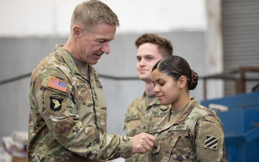 Gen. James C. McConville, Army chief of staff, promotes Pfc. Jeslyam Martinez-Morales, a soldier assigned to the 3rd Combat Aviation Brigade of the 3rd Infantry Division, from private first class to specialist during McConville’s visit to Fort Stewart and Hunter Army Airfield, Ga., on March 23, 2022.