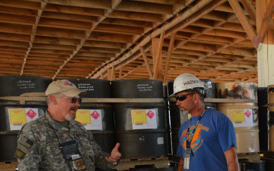 A contracting officer speaks with an employee at the hazardous materials depot operated by contractor Fluor, Bagram airfield, Afghanistan, October 14, 2014. Federal judge re-authorizes Fluor suit arising from 'a suicide bombing in Bagram in 2016 to continue, according to court documents.