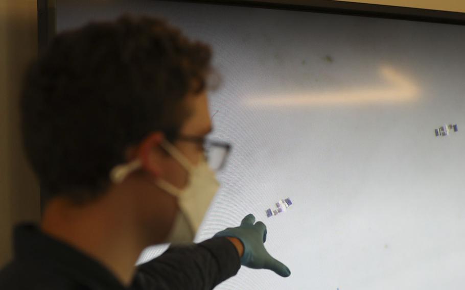 Doctoral student Lucas Hanson points to CMOS Integrated, Sub-1mm Robots, that is shown from a microscope, during the Penn Engineering and Applied Sciences of General Robotics, Automation, Sensing and Perception Lab (GRASP) Technical Tours at the Pennovation Center on May 23, 2022.