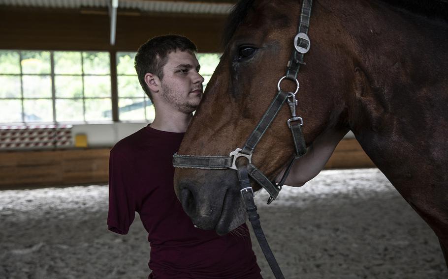 Anatoly nestles a horse during a hippotherapy session at a farm in Sukhodil, Ukraine. 