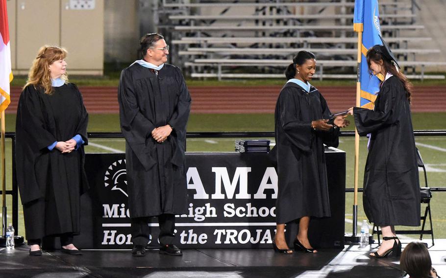 A student from Zama Middle-High School accepts her diploma during the commencement ceremony at Camp Zama, Japan, Wednesday, May 23, 2023.