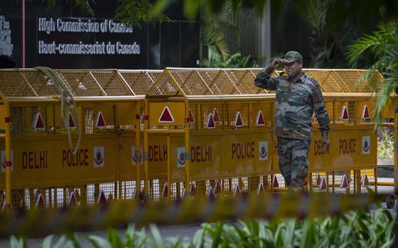 An Indian paramilitary soldier stands guard next to a police barricade outside the Canadian High Commission in New Delhi, India, Tuesday, Sept. 19, 2023. Tensions between India and Canada are high after Prime Minister Justin Trudeau's government expelled a top Indian diplomat and accused India of having links to the assassination in Canada of Sikh leader Hardeep Singh Nijjar, a strong supporter of an independent Sikh homeland. (AP Photo/Altaf Qadri)
