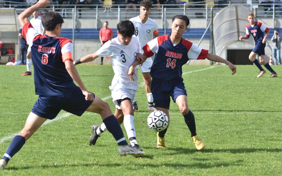 Vicenza's Brandon Prado is sandwiched by Aviano's Xavier Fox, left, and Keoni Andres while Cougars' teammate Anthony Poropat watches Saturday, April 22, 2023.