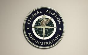 FILE - A Federal Aviation Administration sign hangs in the tower at John F. Kennedy International Airport in New York, March 16, 2017. Congressional negotiators have agreed on a $105 billion bill designed to improve the safety of air travel after a series of close calls between planes at the nation’s airports. (AP Photo/Seth Wenig, File)
