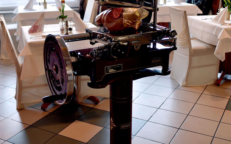 A standing meat slicer in a restaurant dining room.