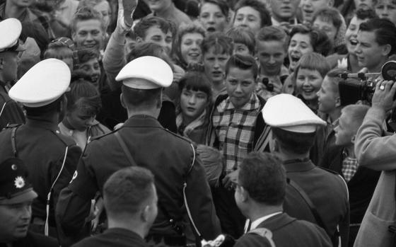Despite foggy weather, by 7:30 am the dockside was already crowded withElvis fans although the USS Randall, with Pvt Elvis Presley aboard, was not due in until 8:30. MPs, SPs, and German police locked arms to hold back the surging youngsters, after the fans broke through the barricades and into the roped off area.

Read Stars and Stripes' 2017 article on Elvis' time in Germany here.
https://www.stripes.com/when-the-king-played-grafenwoehr-elvis-s-only-gi-european-concert-1.499592

Looking for Stars and Stripes’ historic coverage? Subscribe to Stars and Stripes’ historic newspaper archive! We have digitized our 1948-1999 European and Pacific editions, as well as several of our WWII editions and made them available online through https://starsandstripes.newspaperarchive.com/

META TAGS: music; entertainment; rock and roll; Elvis Presley;  Army; military service; Military Police; MP; 