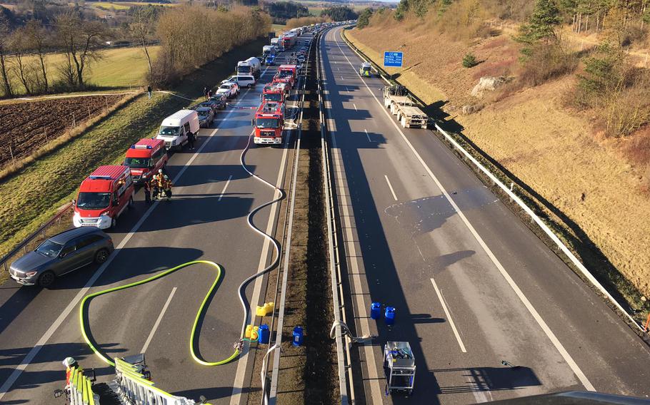 First responders stopped four lanes of traffic on Autobahn 3 near Parsberg, Germany, on Dec. 20, 2021. A truck hit a U.S. military vehicle parked in the emergency lane, sparking a fire in which the truck driver was killed. 