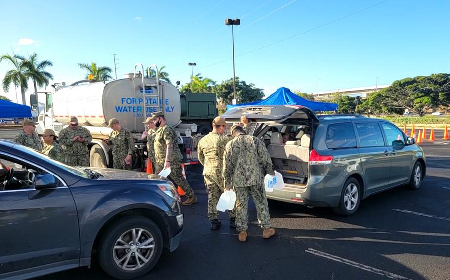 Sailors load water into a car at the Navy Exchange just outside of Joint Base Pearl Harbor-Hickam, Hawaii, Dec. 1, 2021. It is one of three water distribution sites set up by the Navy for residents of military housing experiencing foul-smelling tap water in their homes.