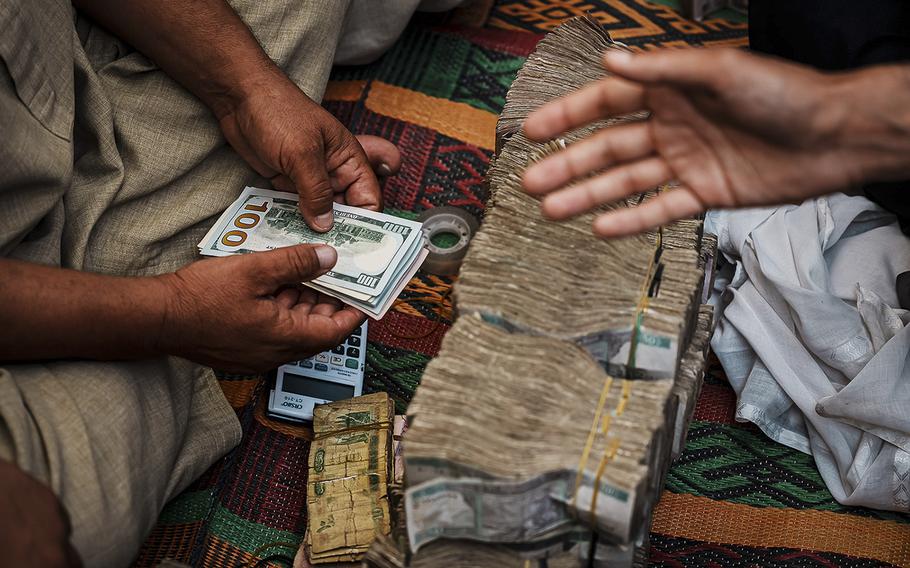 Money exchangers exchange Afghan currency for U.S. dollars at the Sarai Shahzadah, Kabul’s currency exchange market, in Kabul, Afghanistan, on Sept. 7, 2022. 