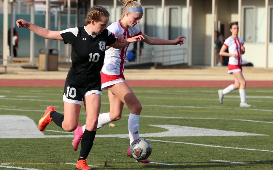 Nile C. Kinnick newcomer junior Hailey Witt, with ball against Zama‘s Olivia Parish, has 11 goals thus far this season and scored seven times during the Red Devils’ two wins Saturday in the Trojan War Cup.
