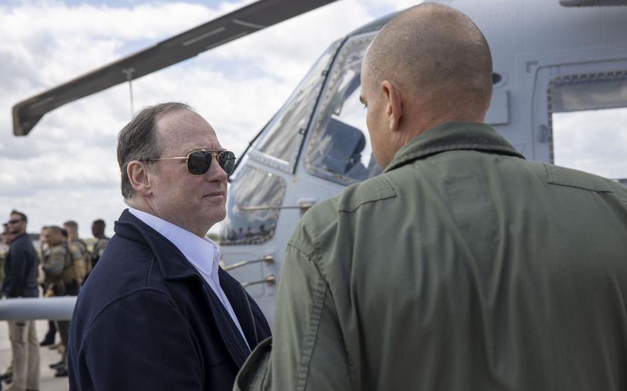 Phelan talks to an officer next to a helicopter.
