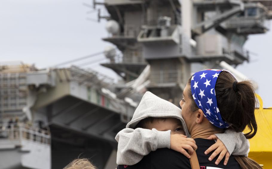 Kelly Holbert comforts her son, Kelly Michael Holbert, 3, as they wave to her husband Petty Officer 1st Class Drew Holbert aboard the USS Dwight D. Eisenhower as it deploys from Naval Station Norfolk on Oct. 14, 2023, in Norfolk, Va. 