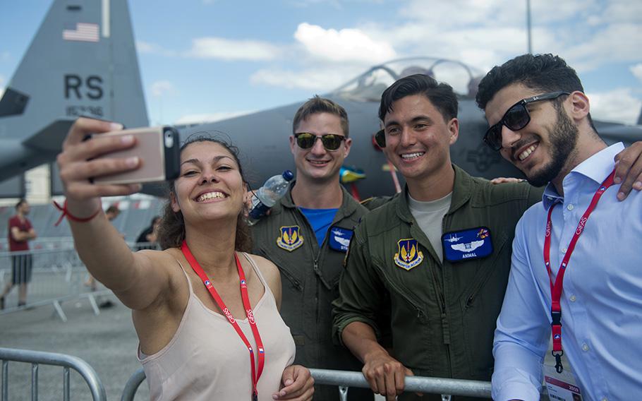 U.S. Air Force 1st Lt. Brandon “Animal” Shelley, a 492nd Fighter Squadron weapon systems officer from the 48th Fighter Wing at Royal Air Force Lakenheath, England, poses for a photo with visitors in front of an F-15E Strike Eagle from his squadron at the Paris Air Show, June 21, 2019. 