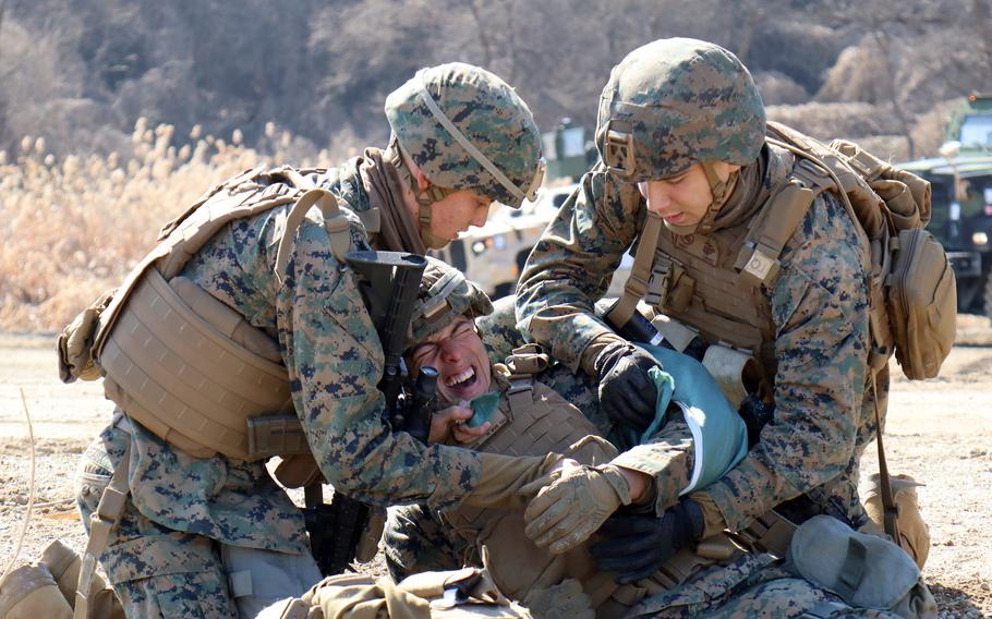 Marines apply a tourniquet to a mock casualty during the Bushido Strike exercise at Dagmar North Training Area in Paju, South Korea, Feb. 21, 2023. 
