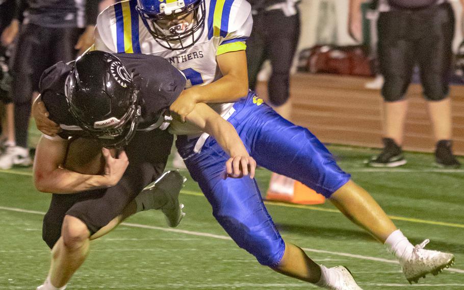 Zama quarterback Dominic Peruccio bulls ahead as he’s tackled by Yokota’s Tre Perkins.