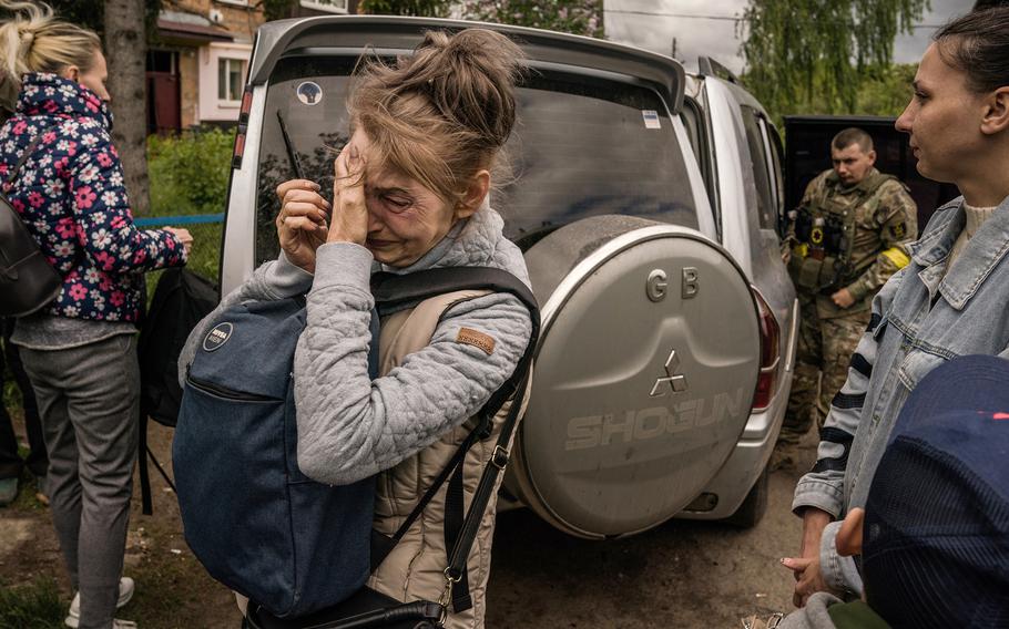 A woman cries while being evacuated from Kutuzivka.