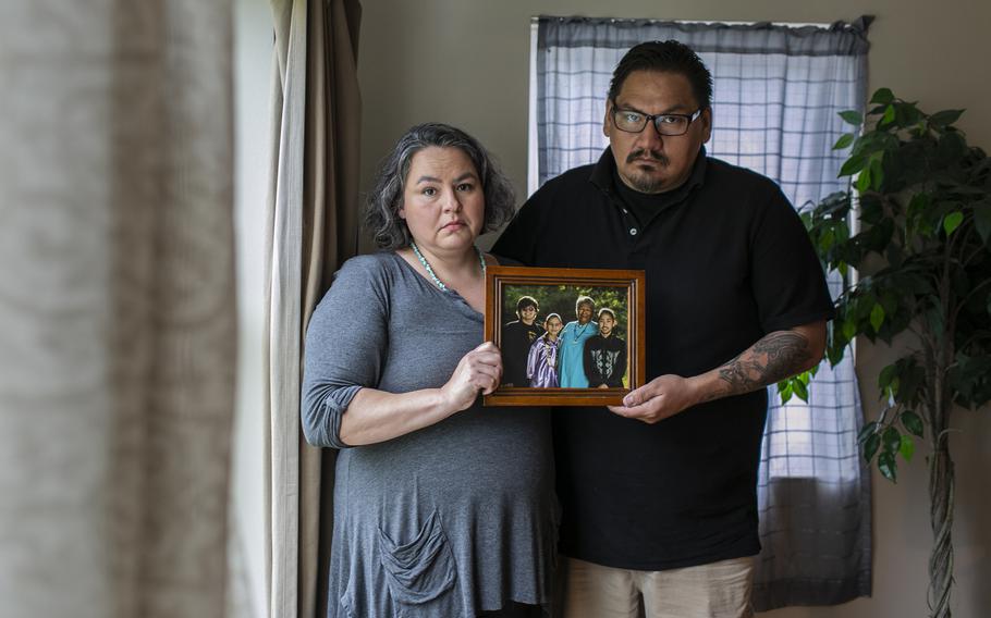 Amanda and her brother, Shane Steindorf, hold a family photo that their mother is in. 