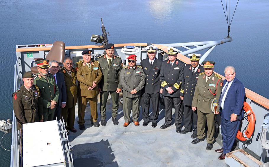 A family photo of civilian and military leaders on a ship.