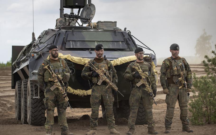 German Bundeswehr soldiers of the NATO enhanced forward presence battalion wait to greet German Chancellor Olaf Scholz upon his arrival at the Training Range in Pabrade, north of the capital Vilnius, Lithuania, Tuesday, June 7, 2022.