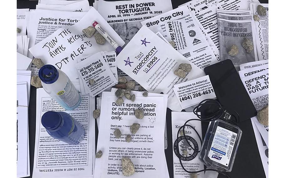 A folding table at the entrance to the forest is spread with fliers listing numbers activists can call for legal help if they are arrested. They also offer instructions for writing to fellow activists jailed on domestic terrorism charges.