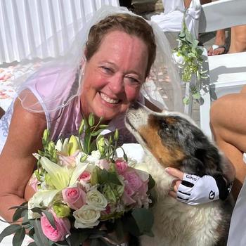 A woman poses with a dog after just getting married. 