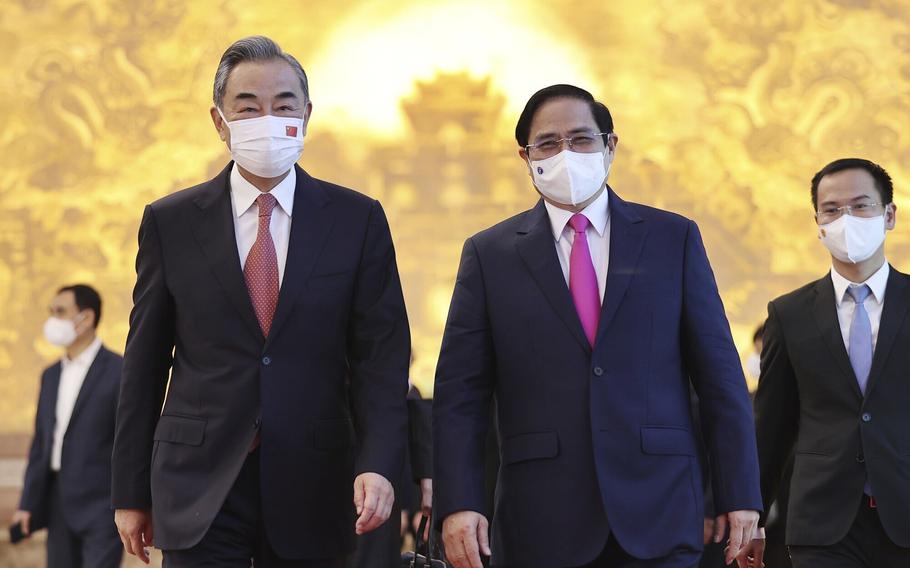 Vietnamese Prime Minister Pham Minh Chinh and Chinese Foreign Minister Wang Yi walk into meeting room in Hanoi, Vietnam, on Saturday, Sept. 11, 2021.