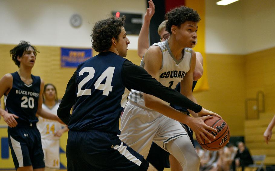 Vicenza sophomore Simon Gilbert fights through the defense by Black Forest Academy senior Daniel Byle during a Division II semifinal at the DODEA European Basketball Championships on Feb. 16, 2024, at Wiesbaden High School in Wiesbaden, Germany.