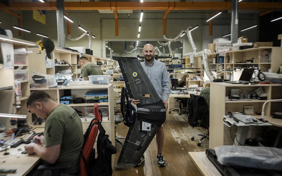 Dmytro Kovalchuk, co-founder of Warbirds of Ukraine, holds a Galka drone in the company's production workspace. 