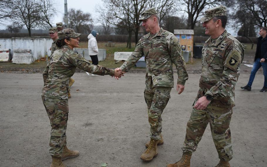 Maj. Gen. JP McGee and Army Chief of Staff Gen. James McConville mingle with soldiers from the 101st Airborne Division, who are on a deployment to Mihail Kogalniceanu Air Base, Romania. McGee and McConville discussed the security situation in the region during a Dec. 16, 2022 visit. 