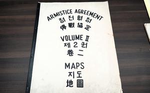 A large booklet that says “Armistice Agreement Maps Volume II” on the cover in black lettering and translated into Chinese and Korean.