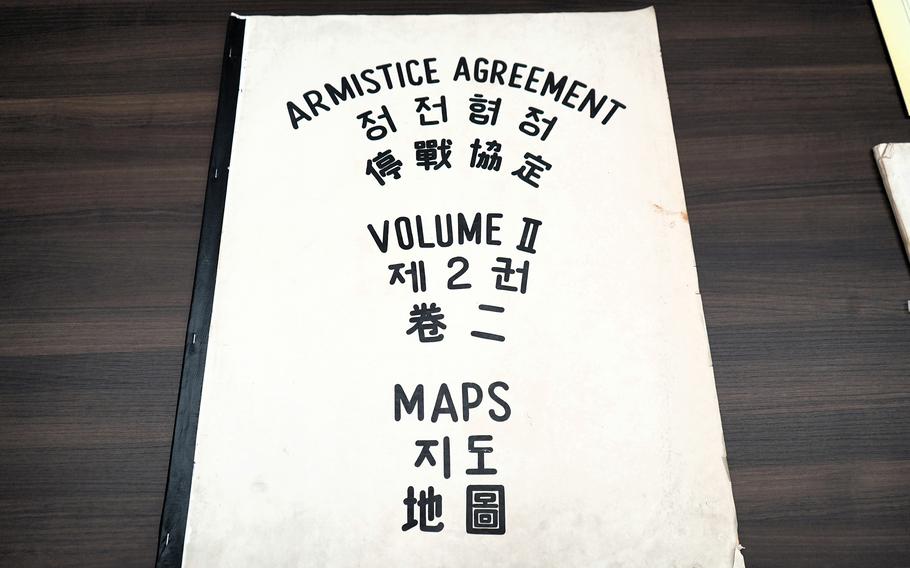 A large booklet that says “Armistice Agreement Maps Volume II” on the cover in black lettering and translated into Chinese and Korean.