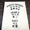 A large booklet that says “Armistice Agreement Maps Volume II” on the cover in black lettering and translated into Chinese and Korean.