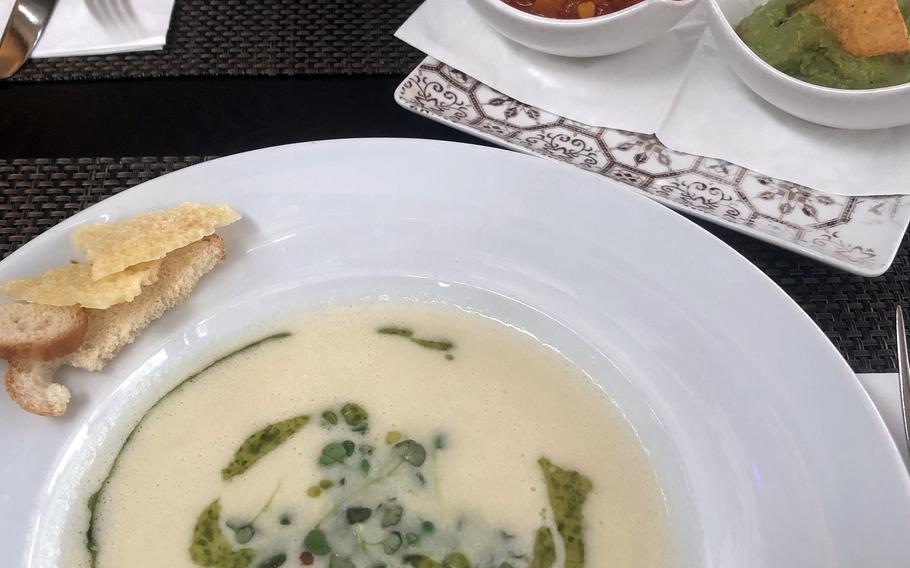 A Parmesan soup, foreground, and nachos with guacamole and homemade salsa, as served at Lumen in Wiesbaden.