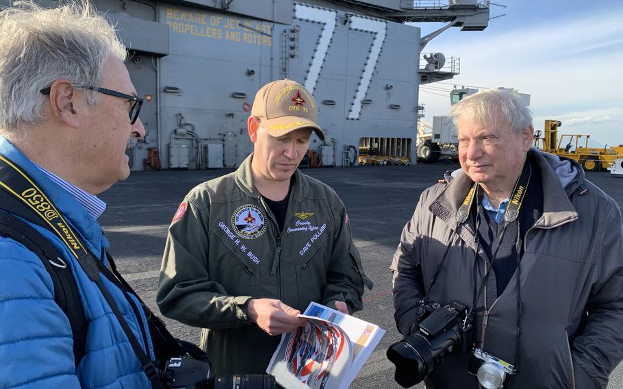 Capt. David-Tavis Pollard, center, commanding officer of the USS George H.W. Bush, speaks with reporters aboard the ship on Nov. 29, 2022. Pollard and other officials said the George H.W. Bush Carrier Strike Group is supporting NATO operations in southern Europe.