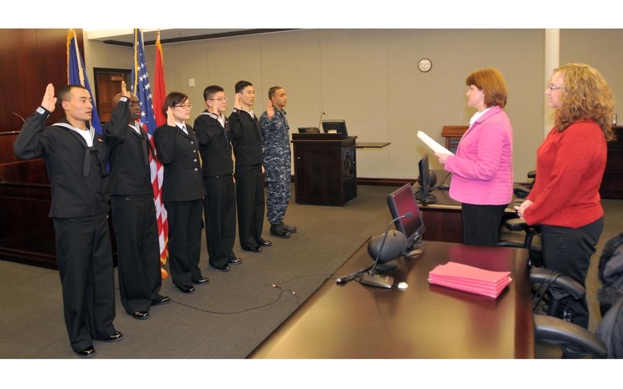 The first Navy sailors to participate in the Secretary of Defense’s Military Accessions Vital to National Interest pilot program are issued the oath of citizenship by Stacey Summers, branch chief from the U.S. Citizenship and Immigration Services Chicago field office, in 2010. 