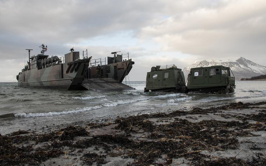 An all-terrain, tracked vehicle known as a Bandvagn is offloaded on a beach in Sandstrand, Norway, on March 21, 2022, during a multinational amphibious landing that was part of the Cold Response military exercise. 