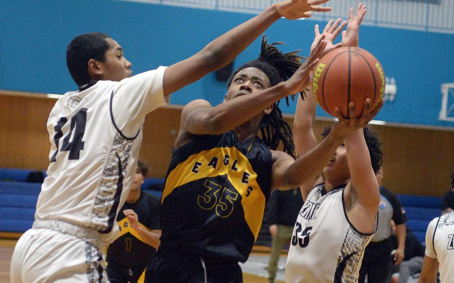 Edgren's JeShawn Spaights-Pace drives between Zama defenders Derek Smith and Kosey Hameen. The Trojans won 49-38.