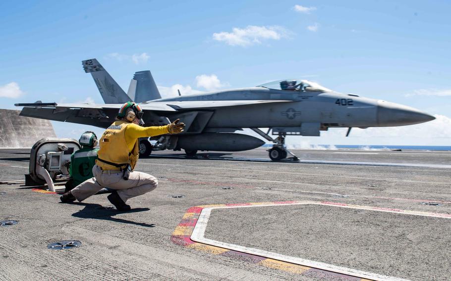 U.S. Navy Lt. Kristin Hope signals to launch an F/A-18E Super Hornet from Strike Fighter Squadron (VFA) 195 from the flight deck of the USS Ronald Reagan (CVN 76) during flight operations in the East China Sea, Aug. 22, 2019. 