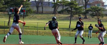 Daegu's Michael Berry finds himself in a rundown against Osan's infield during Saturday's DODEA-Korea baseball game. The Cougars won 7-4.