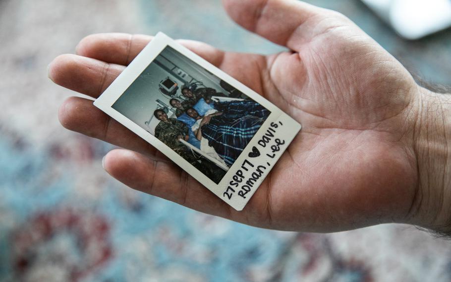 Tabesh holds a photo from his time in a U.S. military hospital in Afghanistan after he was wounded in battle.