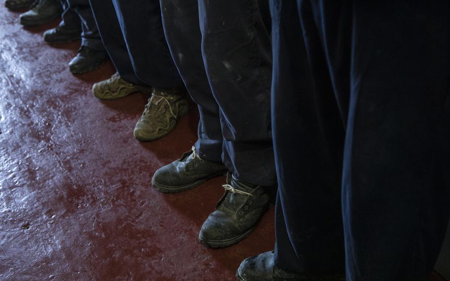 Detained male Russian prisoners of war at a detention camp where Russian prisoners of war are kept in western Ukraine. The prisoners are only allowed to tie their shoes with a short shoe lace for security reasons.