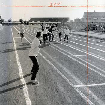 A runner waits for the baton in the 400-meter relay race. The racers were exerting their all on the third leg of the race.